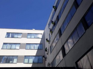 Pracownicy Alpineco myją okna budynku